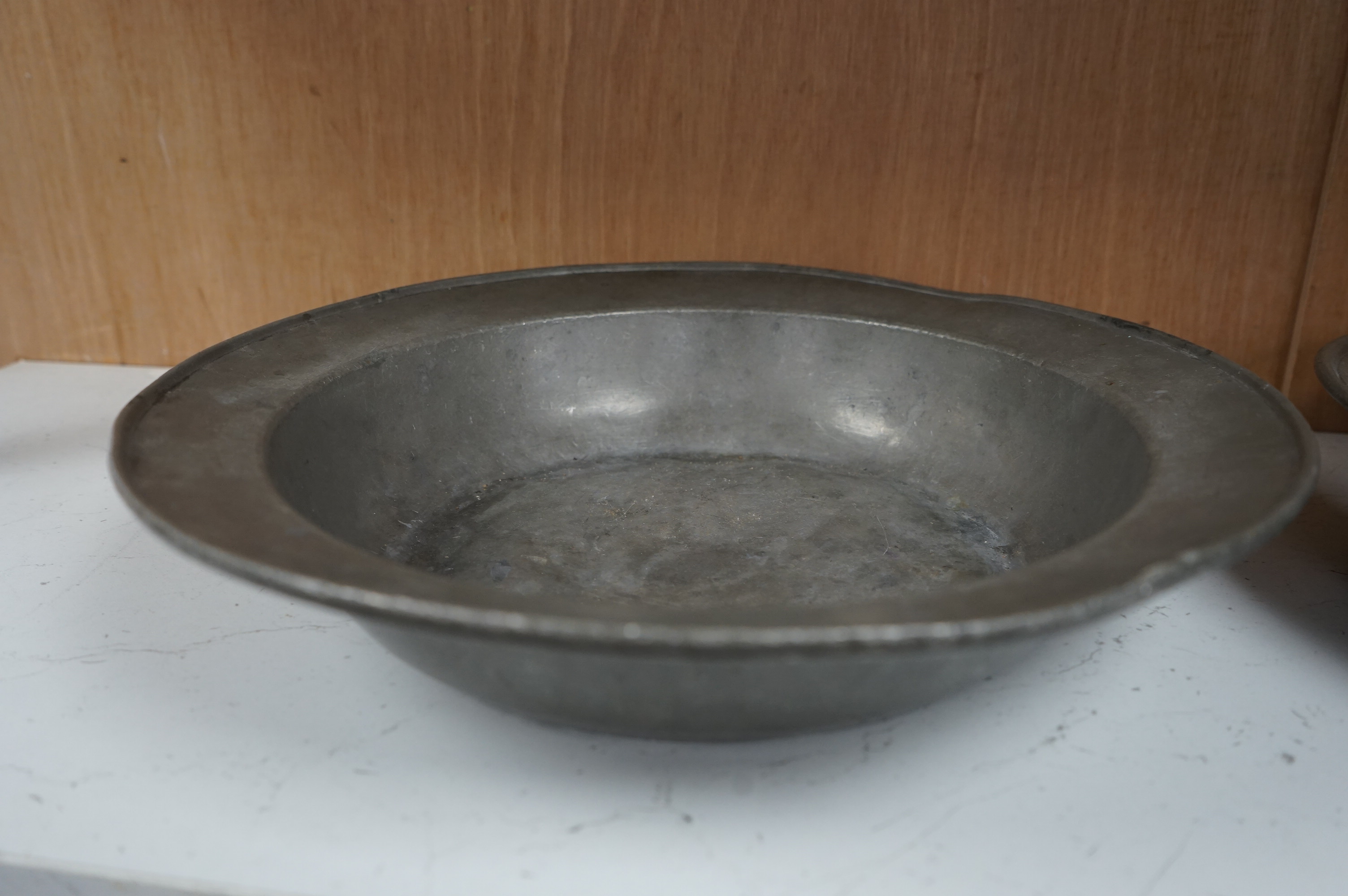 Two 18th century Dutch pewter bowls and a dish, largest 33cm high. Condition - fair, misshapen